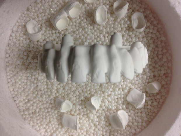 CAD/CAM zirconium frames, embedded in pearl powder before sintering